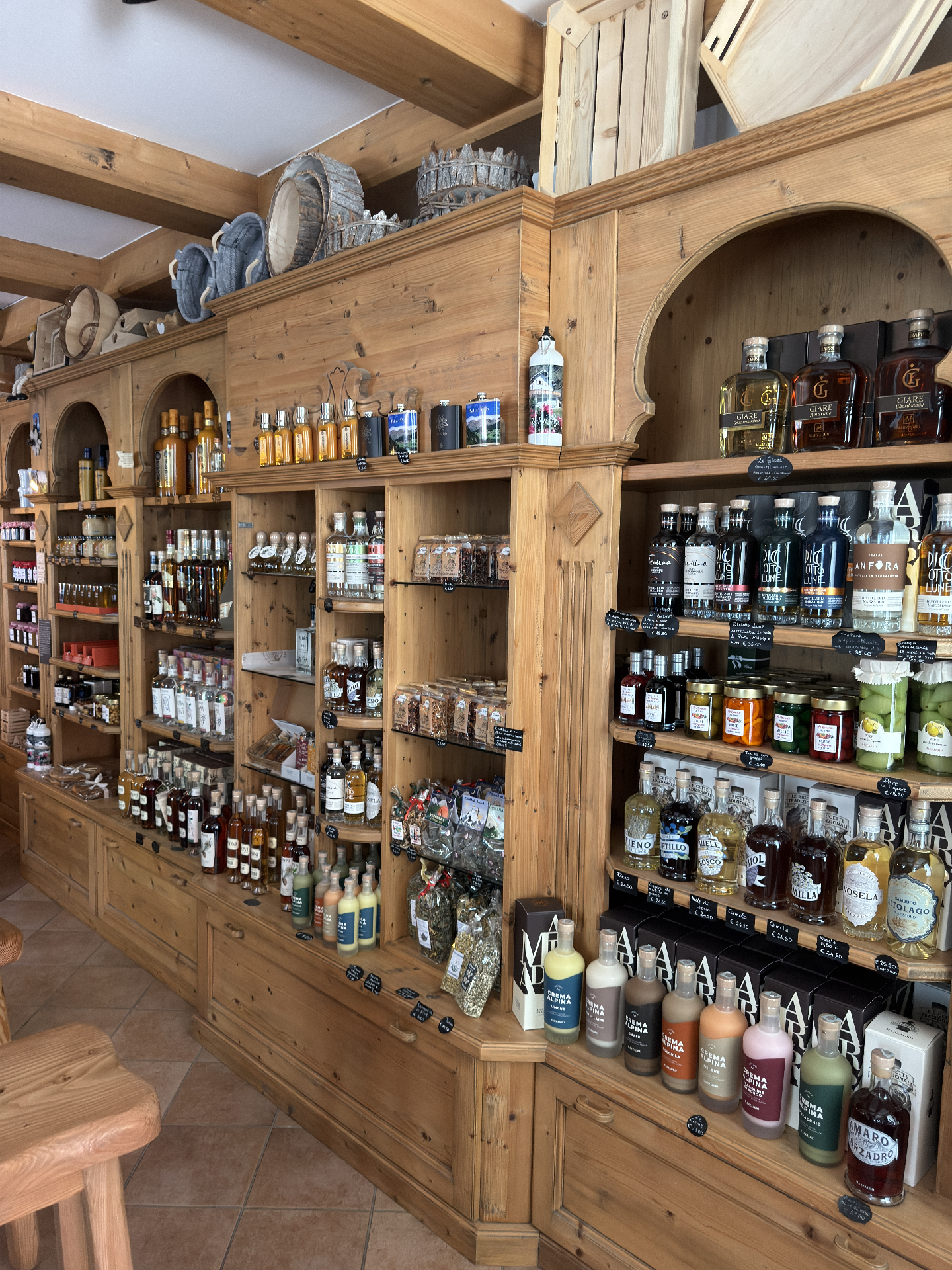 Scaffali in legno con grappe e distillati trentini